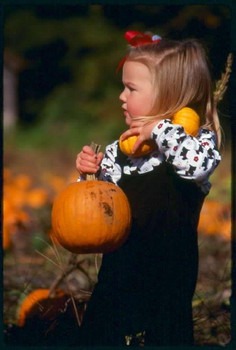 Child carrying pumpkins image